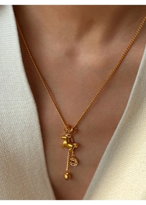 Detailed view of 24K gold-plated necklace with pony and copper coin charm on a model neck