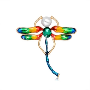Detailed macro view of gold dragonfly brooch with colorful enamel wings and green gemstone