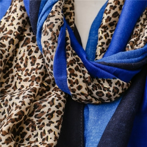 Close-up of leopard print scarf with gold foil details and blue color blocking