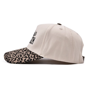 Side view of trucker hat with cream cotton crown and leopard print brim detail