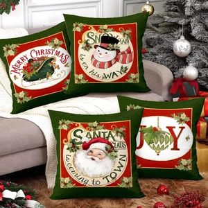 Christmas pillow covers set of 4 with red and green sleigh illustrations on a grey sofa