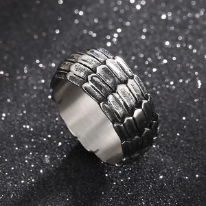 Macro detail of punk style stainless steel ring with black dragon scale textured pattern