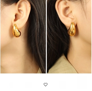 Detail shot of chunky gold water-drop earrings showing the glossy mirror finish and fit