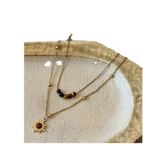 Collier double rang œil de tigre doré avec pendentif tournesol sur plateau céramique