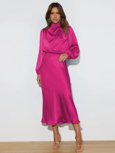 Close-up of magenta satin dress showing mock neck detail and silky fabric texture