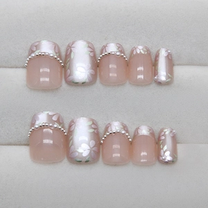 Pink pearl press-on nails with cherry blossom patterns and elegant pearl embellishments