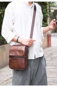 Men's brown genuine leather vertical crossbody bag shown on a model in outdoor lighting