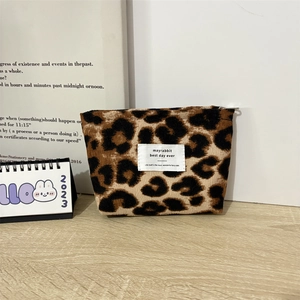 Detail of leopard print corduroy makeup pouch with textured fabric and vintage label