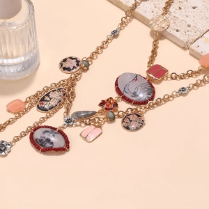 Multi-layer vintage necklace with crane charms, floral enamel, and golden chain details