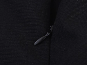Vue macro de la fermeture éclair en métal sur une robe noire dos nu élégante