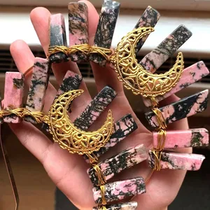 Detail of handmade gold crescent moon crown with pink and black natural mineral stones