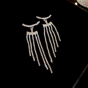 Detailed view of silver bow-shaped drop earrings with shimmering white rhinestones