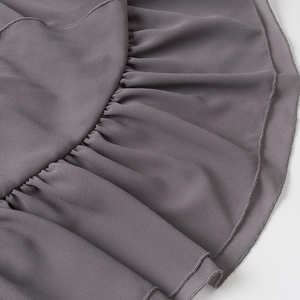 Dettaglio del tessuto in chiffon grigio con volant e finiture di cucitura rifinite