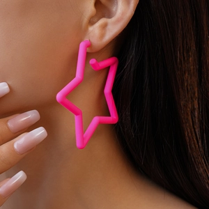 Gros plan d'un mannequin portant une boucle d'oreille étoile en acrylique rose vif poli