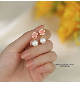 Detail of S999 sterling silver pink cherry blossom earrings with elegant white pearls