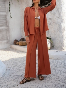Detail of orange-red shirt and wide-leg trousers set with high-end textured fabric