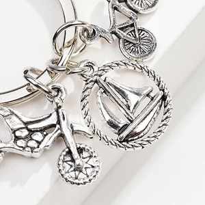 Detail of silver alloy keychain with vintage bicycle, sailboat, and motorcycle pendants
