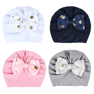 Set of four waffle texture baby turban hats with large gold polka dot bows for infants