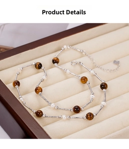Detailed shot of tiger eye stone and freshwater pearl beaded necklace in a jewelry box
