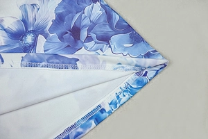 Macro view showing floral print fabric and precise overlock stitching on sleeve hem