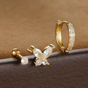 Macro shot of gold butterfly stud and zircon hoop earrings showing S925 hallmark