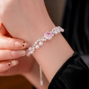 Double-layered pearl bracelet featuring a pink zircon centerpiece on a model's wrist