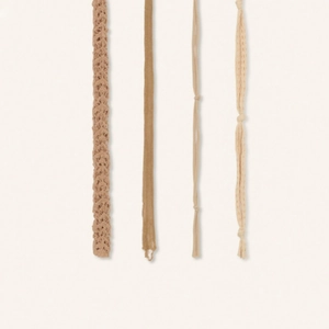 Détail de quatre écharpes aux tons désert avec des textures crochetées et tricotées