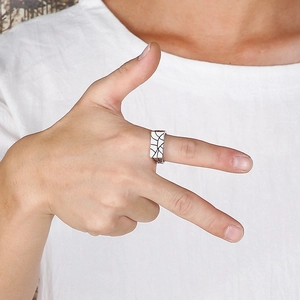 Vintage silver stainless steel ring with black geometric patterns worn by a person