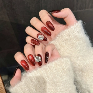 Red cat eye press-on nails with luxury rhinestones and almond shape for festive style