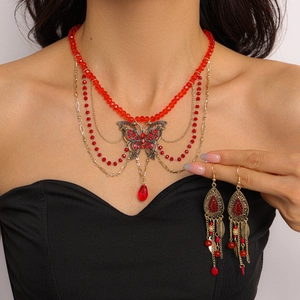 Detail of red beaded necklace with butterfly pendant and matching tassel earrings