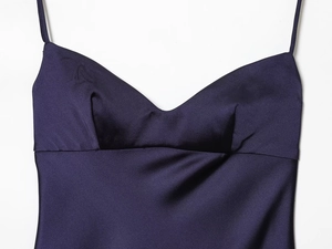 Gros plan du décolleté de la robe nuisette en satin violet foncé aux détails soyeux lisses