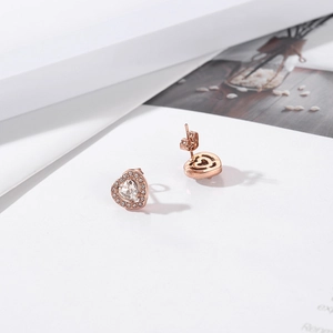 Macro view of heart-shaped zircon earrings with rose gold plating and halo setting