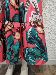 Close-up of bright pink floral print fabric on a long sleeveless summer strap dress