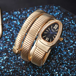 Detailed view of the gold serpent head watch dial with crystals on a navy background