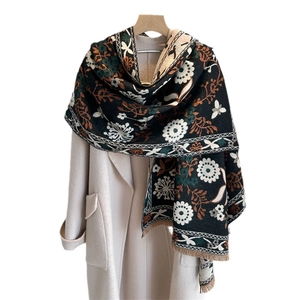 Floral cashmere-like scarf in black jacquard, elegantly draped over a beige winter coat