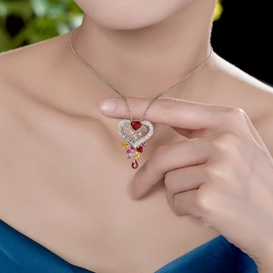 Detailed view of luxury heart-shaped ruby necklace with colorful pear-cut gems on model