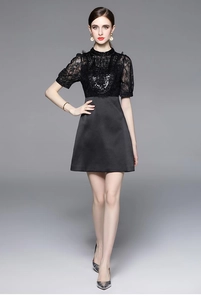 Detailed view of luxury black dress featuring lace patchwork and intricate beadwork details