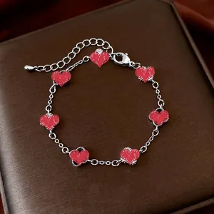 Elegant vintage style bracelet with seven red heart pendants on a silver metal chain