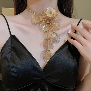 Detail of multi-layer gold choker necklace with rhinestone flower tassels on model