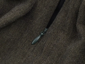 Detail of invisible zipper on dark brown coarse woven fabric for mini dress