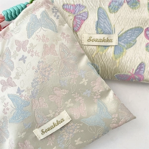 Close-up of jacquard fabric texture and colorful butterfly patterns on crossbody bags