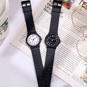 Flat lay of black quartz watches with white and black dials on a desk with a coffee cup