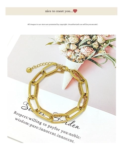 Detail of gold titanium steel double-layer chunky chain bracelet with long pendant charm