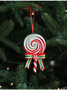 Close-up of red and green Christmas candy cane ornament hanging on a festive tree branch