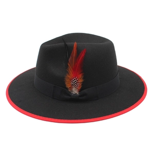 Close-up of black wool fedora with red contrast brim and decorative feather accent