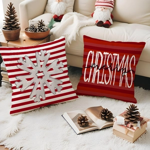 Close-up of red and white Christmas snowflake pillow covers on a cozy sofa setting