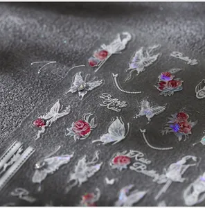 Macro detail of 5D embossed nail stickers featuring elegant white butterflies and red roses