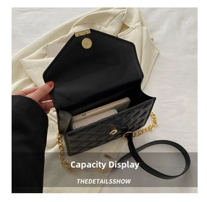 Internal view showing the capacity of a black quilted chain bag holding a smartphone