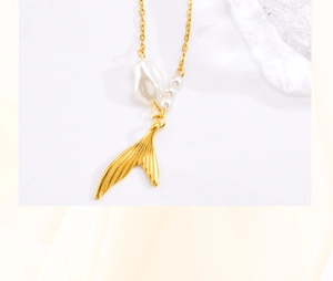 Macro shot of gold fishtail pendant necklace with elegant baroque pearl and round pearls