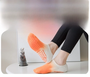 Detail showing orange gradient yoga socks with non-slip silicone grips and Angel text